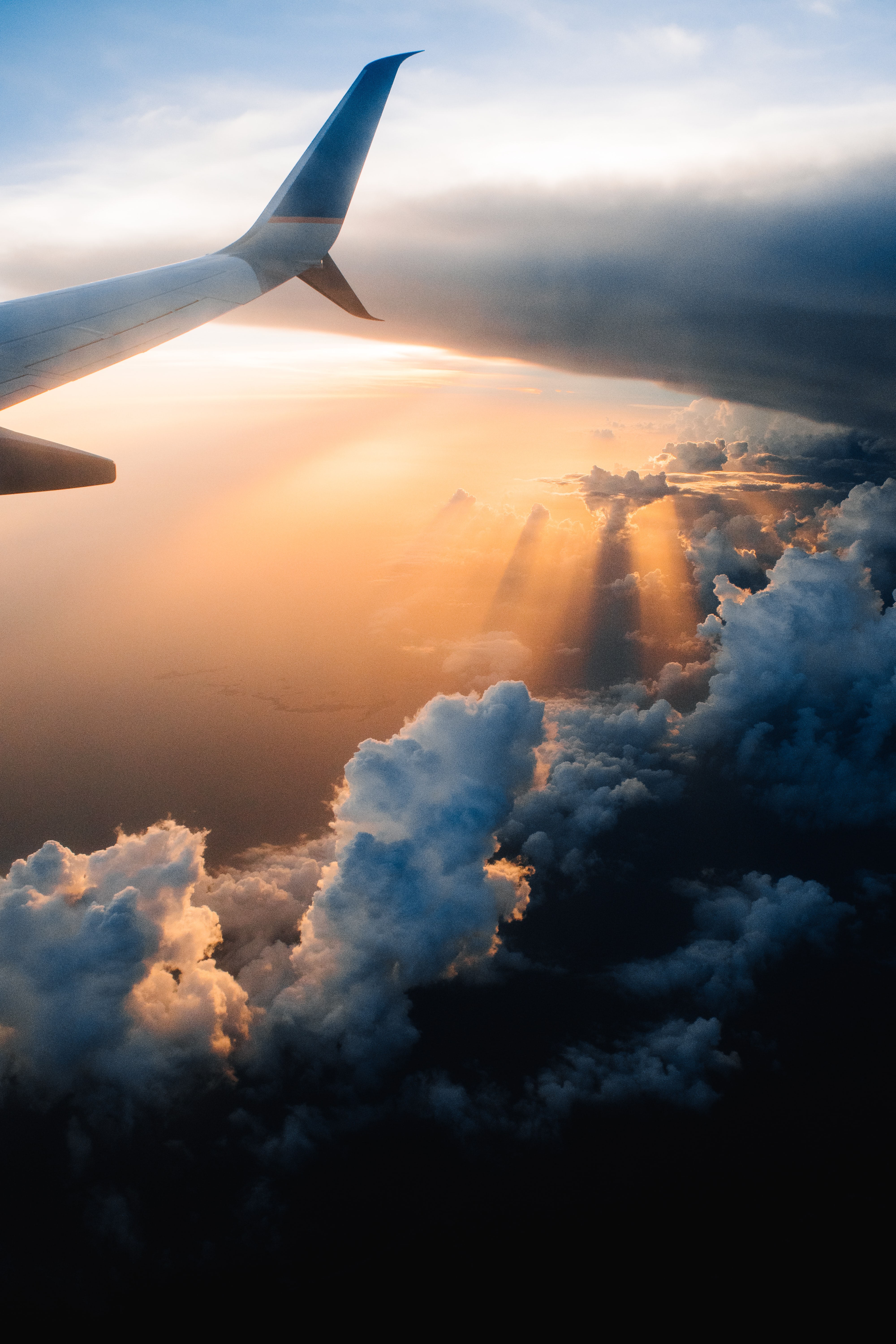Sunlight spilling over clouds viewed from an airplane window